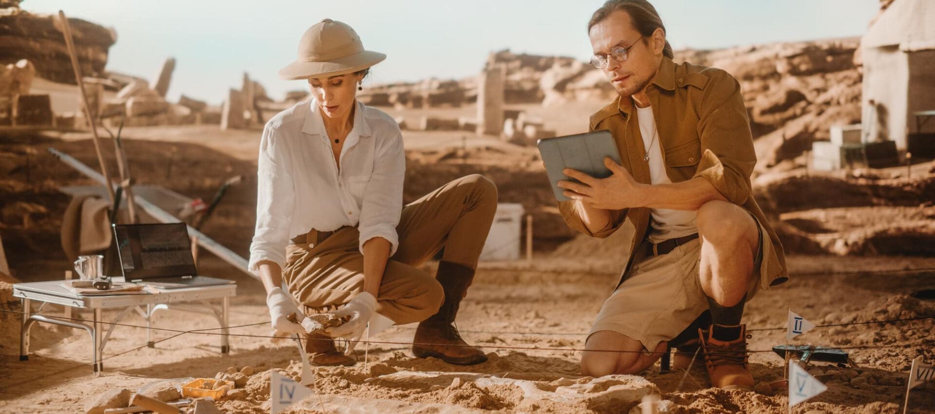 Two paleontologists use a tablet to analyze a newly discovered dinosaur skeleton